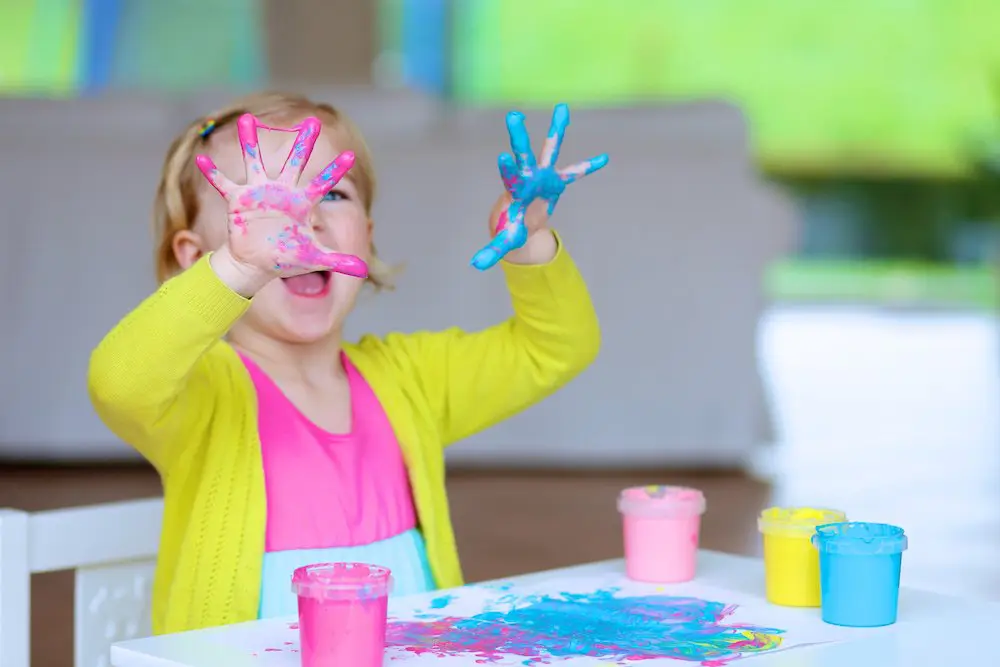 Toddler playing with paints and learning to be creative