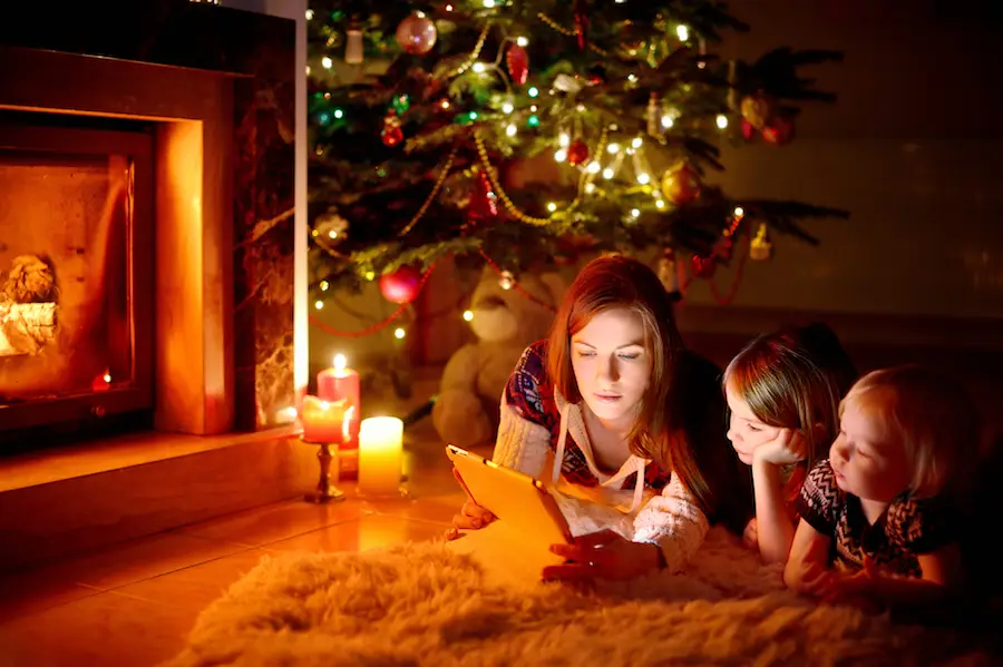 Toddler watching a Christmas movie by the Christmas tree