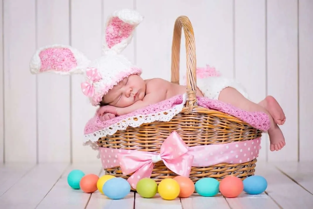 Baby wearing bunny ears with a Easter basket
