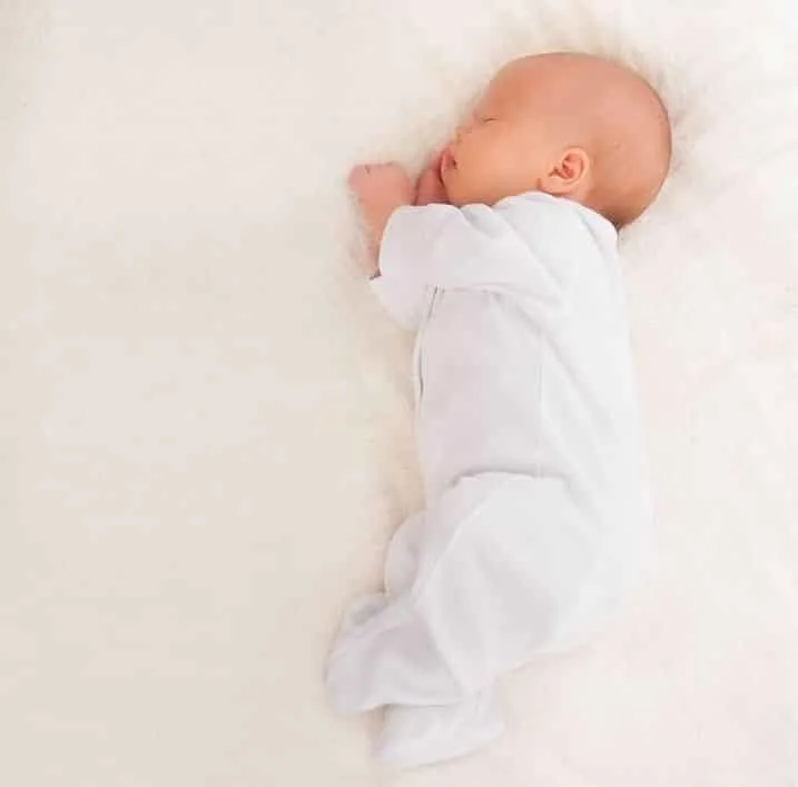baby wearing a baby sleepsuit or babygro