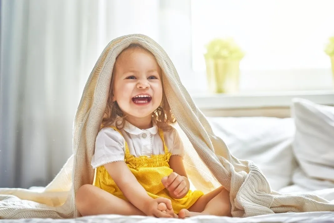 Toddler playing on bed during lockdown