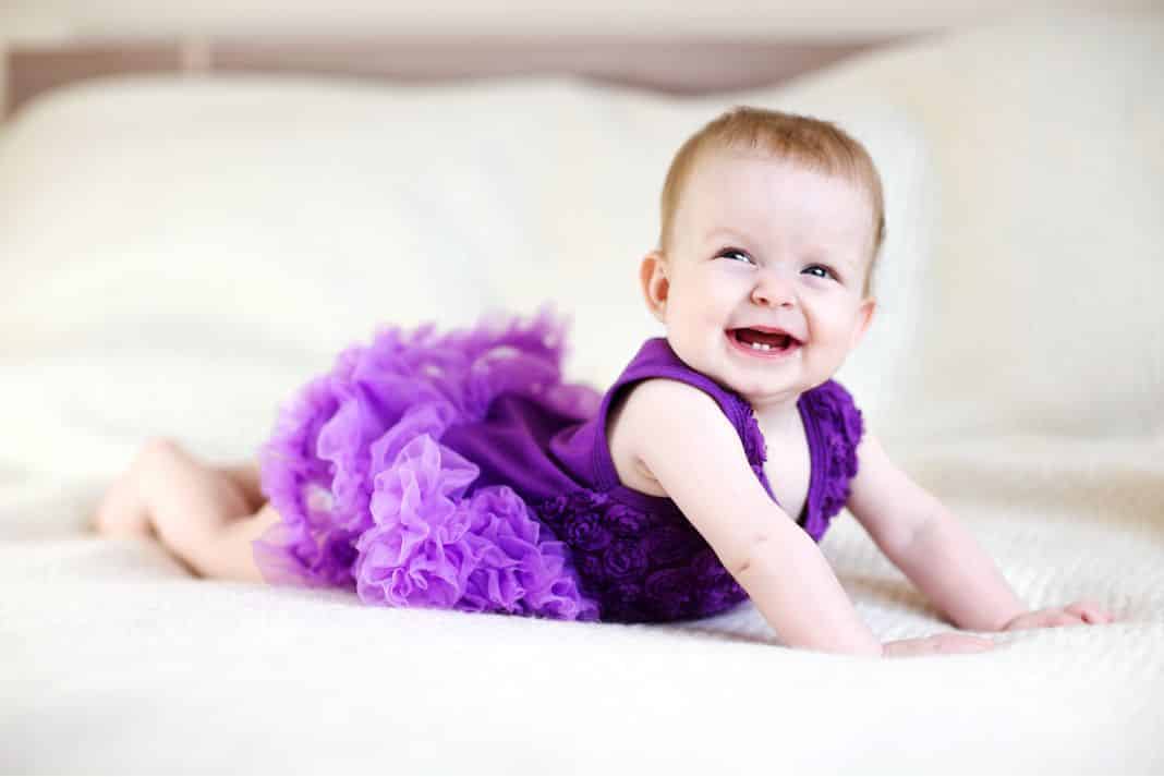 Baby girl in purple tutu smiling 